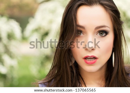 Portrait of young pretty brunette with surprised face