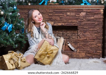 Attractive woman sitting on the carpet near a fireplace