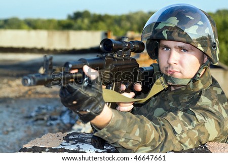 Portrait of the soldier in camouflage with machine gun
