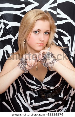 Lovely young blonde stretches out her hands in chains