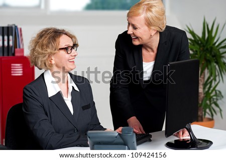 Joyful businesswomen enjoying at work desk during office hours