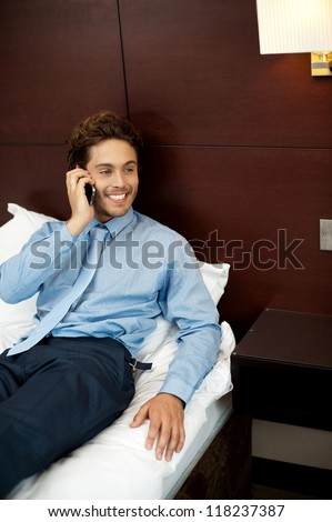 Relaxed cool guy talking on the phone after his long work day