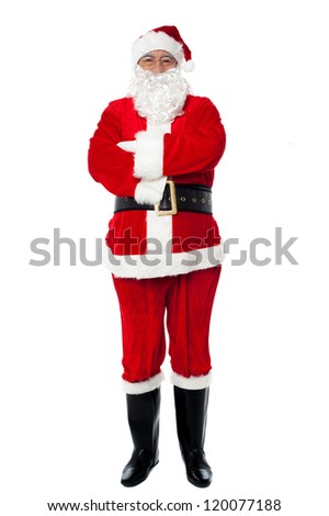 Confident old man in Santa costume posing with arms crossed and smiling at camera