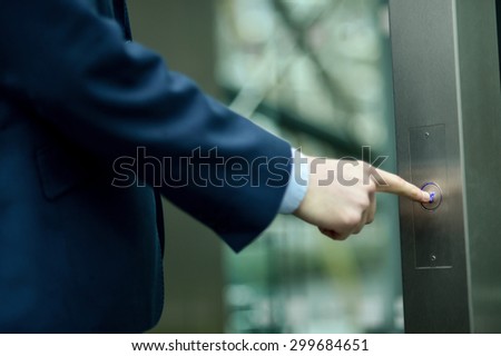 Close up of businessman finger pushing elevator button