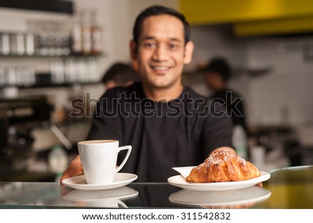 Cheerful male staff serving to his customer