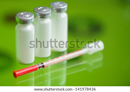 insulin syringe and  vials for injection, with white mortar. objects in macro mode