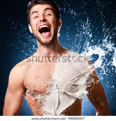emotional man laughs. splashes of milk on his sexy body