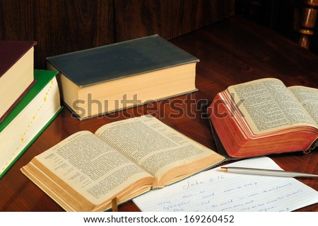 TWINSBURG, OH - JANUARY 16, 2011: Photo of two open Bibles, one in Greek, with other books and study notes, illustrating the concept of researching the original language in Christian Bible study.