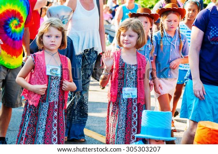 TWINSBURG, OH, USA - AUGUST 8, 2015: Young twins walking in the Double Take Parade, part of the 40th annual Twins Day festival, the largest gathering of twins in the world.