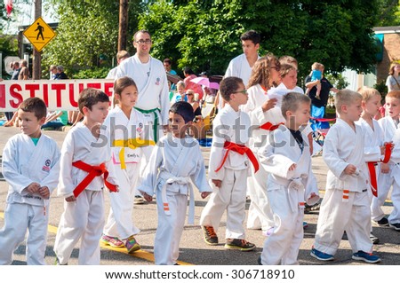 TWINSBURG, OH, USA - AUGUST 8, 2015: Young twins in a karate club walk in the Double Take Parade, part of the 40th annual Twins Day festival, the largest gathering of twins in the world.