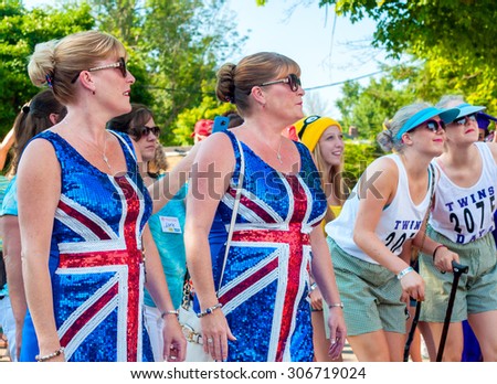 TWINSBURG, OH, USA - AUGUST 8, 2015: Two sets of twin sisters walk in the Double Take Parade, part of the 40th annual Twins Day festival, the largest gathering of twins anywhere in the world.