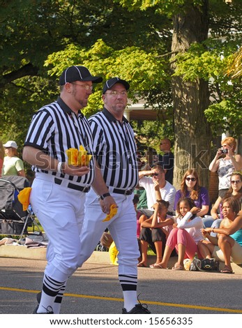 TWINSBURG, OH - TWINS DAYS - AUG. 2, 2008: Twin brothers dressed as football referees walking in the Double Take Parade in the annual Twins Days Festival at Twinsburg, Ohio