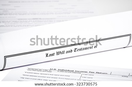 Last Will and Testament rolled up with tax return and  advance health care directive isolated on white shallow depth of field