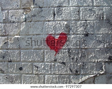 Red heart on a white painted brick wall