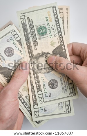 Pair of hands holding a stack of dollar bills.