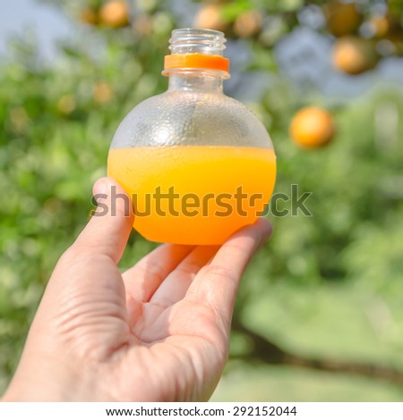The orange juice in the plastic bottle, orange juice bottle in hand