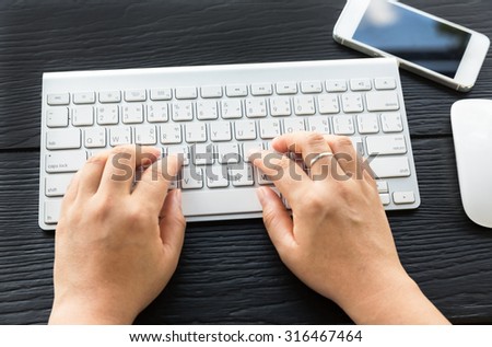 HARD, THAILAND - SEP 11, 2015 hands typing on the iMac wireless keyboard