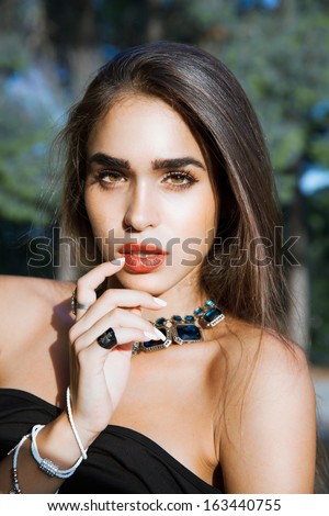 Sensual woman beauty. Jewelry portrait . Woman with bright make up and red lips. Shine healthy skin.Fashion portrait. Mystical face. Indian. Long shine hair. Sexy look. Outdoors shot. Soft colors