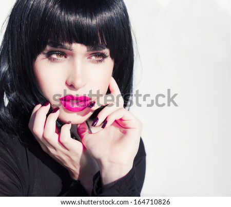 woman with short stylish hairstyle and pink make up.Exotic woman beauty. Black shine hair . Hairdresser. Retro style . Sexy look . Pink lips.