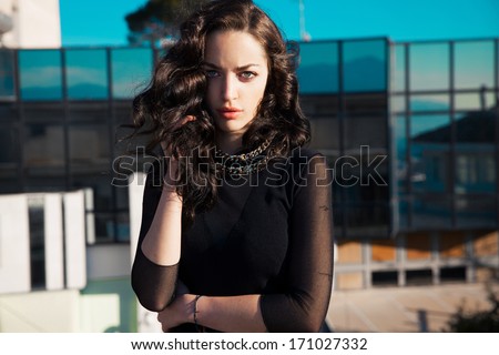 beautiful brunette female with wavy, long shine hair. urban portrait