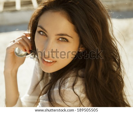 Woman with perfume. Smiling beautiful woman holding bottle of perfume and smelling aroma. horizontal shot