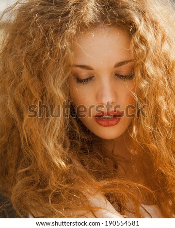 beautiful blonde girl with long hair and bright make up in studio. vertical shot. summer colors