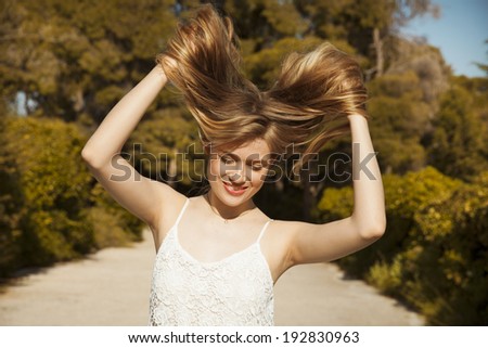 Photo of beautiful woman with magnificent hair.  Long hair blowing in the Wind. Backlit, Warm Color Tones. outdoors shot, horizontal