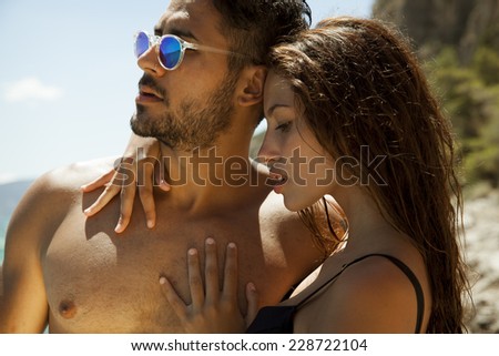 Sexy young passionate couple in bikini. Summer style. Toned in warm colors. Horizontal shot