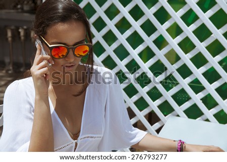 friendly woman speaking on the smart phone in a restaurant terrace  horizontal shot