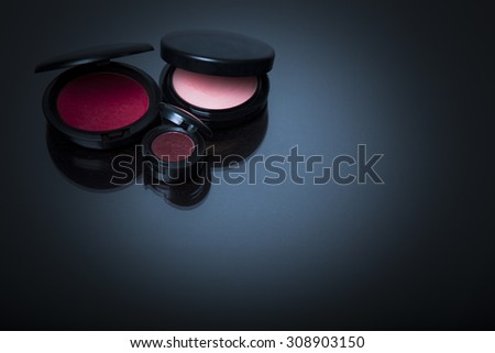 Makeup products on dark background with reflection. Copy space for your text. Studio shot. Horizontal picture