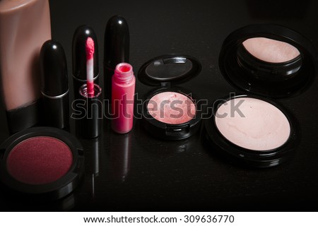 Various makeup products in pink tone with copy-space for your text. Makeup and beauty concept . Dark background. Cosmetics products. Horizontal. Studio shot.