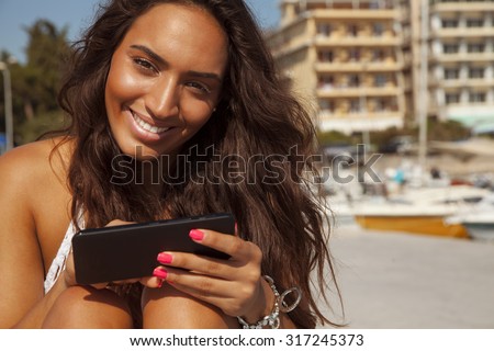 Happy woman playing with her smart phone. Copyspace for your text. Beauty and technology. horizontal outdoors shot.