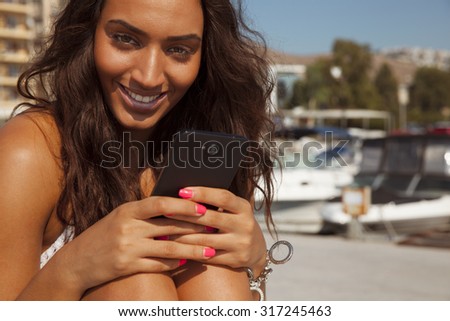 Happy woman playing with her smart phone. Copyspace for your text. Beauty and technology. horizontal outdoors shot.