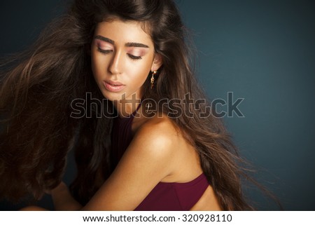 beautiful young woman with healthy and shiny long hair and makeup.  Long straight , blowing hair. Horizontal, studio shot