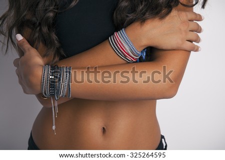 Front side view of woman belly and hand with Accessories. Part of body. Studio shot, Horizontal