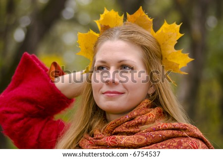 Beautiful young woman wearing ma?le wreath looking away with sad smile