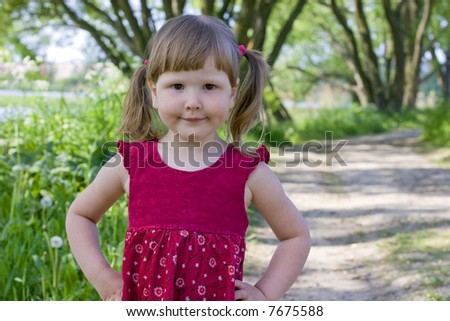 Rural girl in red dress with ponytails looking at you