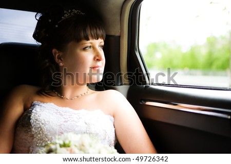 Bride sitting in car before wedding begins thoughtful look