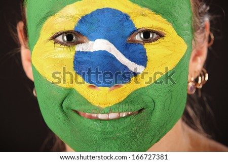 Football fan with face painted in Brazil color on black background