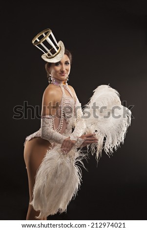 Burlesque dancer in white dress with plumage, isolated on black