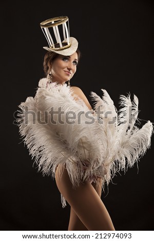 Burlesque dancer in white dress with plumage, isolated on black