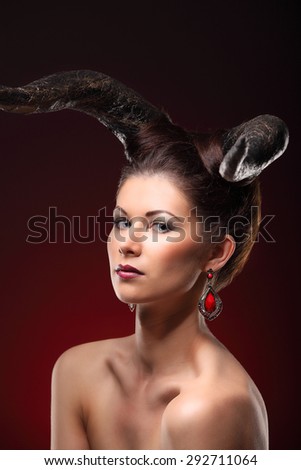 The beautiful young girl with horns like devil or angel studio