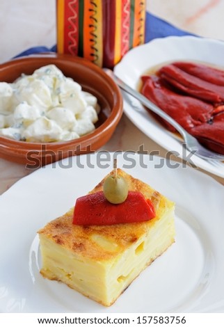 Tapas selection of a square of Spanish Tortilla with roasted red peppers in olive oil and potato salad to the rear (Pimientos del Piquillo Enteros (Asados con Lena), Andalusia, Spain, Western Europe.
