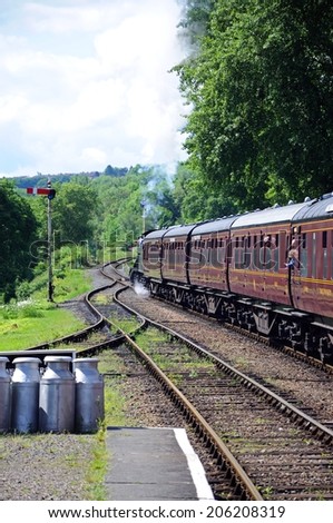 HAMPTON LOADE, UK - JUNE 5, 2014 - Steam train pulling a rake of LMS passenger carriages/coaches in Maroon at the Great Western railway station, Hampton Loade, Shropshire, England, UK, June 5, 2014.