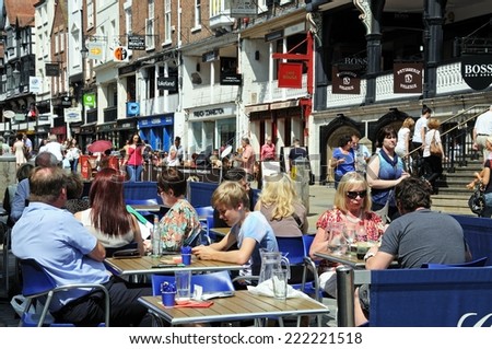 CHESTER, UNITED KINGDOM - JULY 22, 2014 - Pavement cafe outside old shops and buildings along Bridge Street, Chester, Cheshire, England, UK, Western Europe, July 22, 2014.