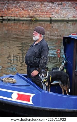 NOTTINGHAM, UK - JULY 17, 2014 - Man and his dog on a narrowboat along the Nottingham and Beeston Canal, Nottingham, Nottinghamshire, England, UK, Western Europe, July 17, 2014.