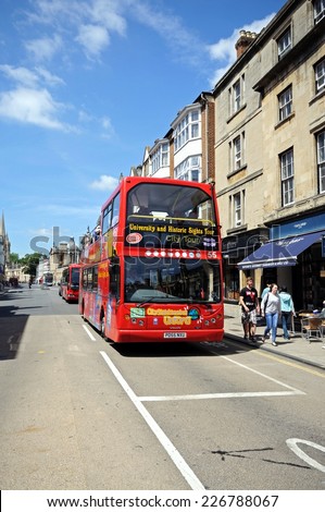 OXFORD, UNITED KINGDOM - JUNE 17, 2014 - Red open topped Oxford tour bus along High Street, Oxford, Oxfordshire, England, UK, Western Europe, June 17, 2014.