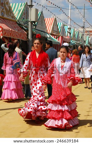 SEVILLE, SPAIN - APRIL 12, 2008 - Girls walking alongside Casitas in traditional dress at the Seville Fair, Seville, Seville Province, Andalusia, Spain, Western Europe, April 12, 2008.