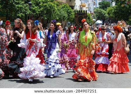 MARBELLA, SPAIN - JUNE 11, 2008 - Women walking along the street wearing flamenco dresses during the Romeria San Bernabe, Marbella, Costa del Sol, Malaga Province, Andalusia, Spain, June 11, 2008.