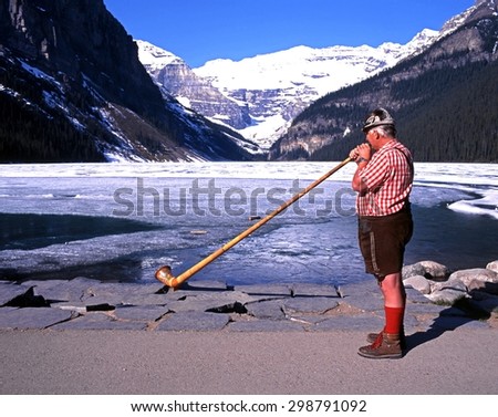 LAKE LOUISE, CANADA - MAY 31, 1995 - Horn blower standing on the edge of the partly frozen Lake Louise, Banff National Park, Alberta, Canada, May 31, 1995.